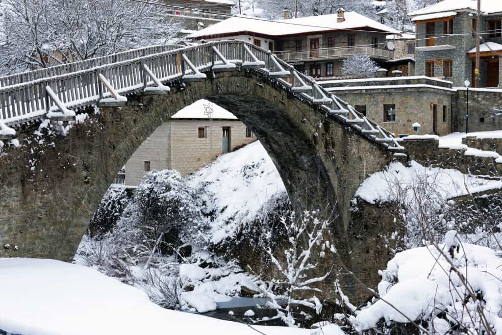 Oude brug met sneeuw in Zagoria, Griekenland